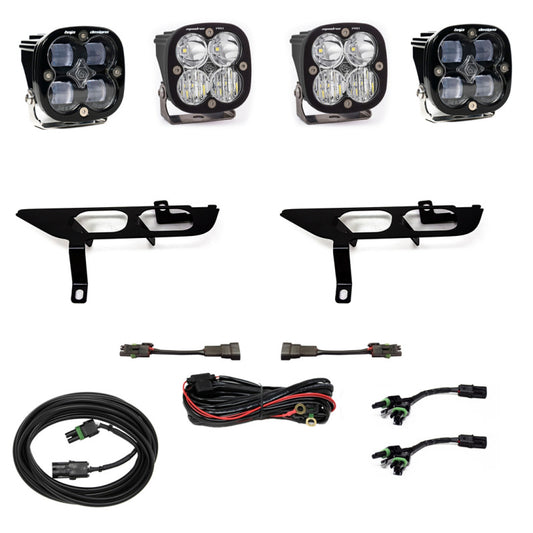 The Baja Designs 2021+ Ford F150 Fog Pocket Kit SAE Clear Squadron Sport DC includes four LED lights from the Squadron Sport series, two black mounting brackets, two wiring harnesses, and connecting cables arranged on a white background. It's a perfect fit for your Ford F150.