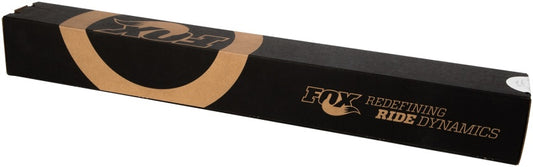 A long, rectangular black box with gold details showcases the FOX logo and the text "Fox Redefining Ride Dynamics" on the side, emphasizing the superior off-road capability of the Fox 99+ Chevy 1500 2.0 Performance Series 9.1in. Smooth Body IFP Rear Shock (Aluminum) / 0-1in. Lift, renowned for its performance-minded shock valving.