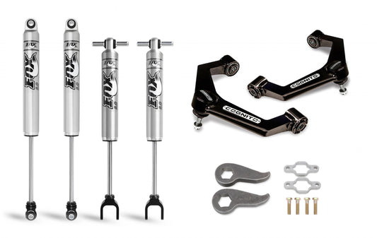 The image showcases the Cognito Motorsports 3-Inch Performance Leveling Kit with Fox PS 2.0 IFP Shocks for 2011-2019 Silverado/Sierra 2500/3500 2WD/4WD, featuring two silver Fox shocks with black branding, two silver struts with black branding, two black control arms with white branding, two wrenches, four bolts, and a set of bushings.