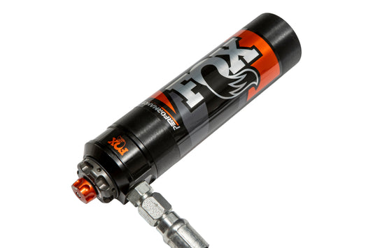 Close-up of a black and orange FOX 21+ Ford Bronco 2.5 Performance Series Rear Coil-Over Reservoir Shock with a silver connector, showing the Fox logo and indicating its use as an adjustable off-road race shock for mountain biking, promising enhanced ride quality.