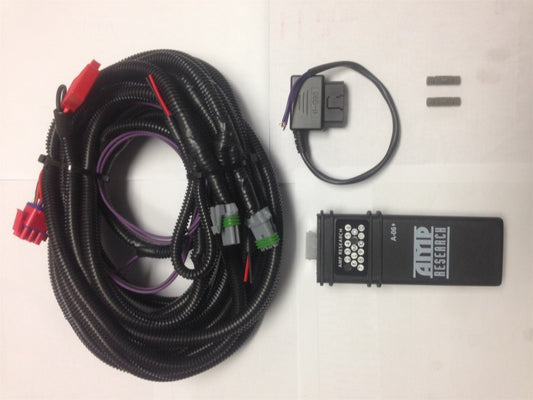 A collection of automotive wiring accessories is displayed on a surface, showcasing a coiled wire harness with connectors, an electronic module designed for all-weather performance labeled "AMP Research," a looped cable, and two small metal connectors. Ideal for your AMP Research 2014-2017 Chevy Silverado 1500 PowerStep Plug N Play installations.