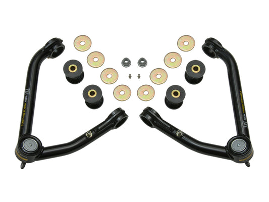 This image features the ICON 14-18 GM 1500 Tubular Upper Control Arm Delta Joint Kit (Large Taper) from ICON, showcasing two black upper control arms equipped with advanced Delta Joint technology. The kit includes multiple bushings, washers, and bolts, all symmetrically arranged against a clean white background.