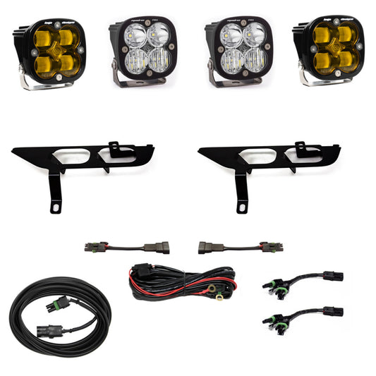 The Baja Designs 2021+ Ford F150 Fog Pocket Kit SAE Amber Squadron Sport DC, featuring a set of four LED off-road lights with yellow lenses, comes with two black bracket mounts, wiring harnesses, and connectors—all perfectly suited for your Ford F150. Everything is neatly arranged on a white background.