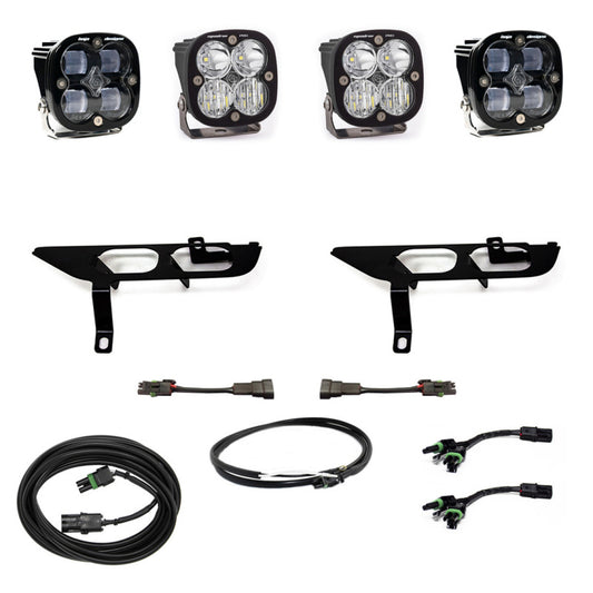 The Baja Designs 2021+ Ford F150 Fog Pocket Kit SAE Clear Squadron Pro DC with Upfitter, featuring Squadron Pro off-road LED lights and specifically designed for the Ford F150, is showcased on a white background. This kit includes four square lights, two black brackets, and a selection of connectors and cables for easy installation.
