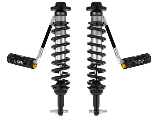 The image shows a pair of black and silver coilovers with attached reservoirs set against a white background. The ICON logo, known for its association with durability and high performance, stands out prominently. Expertly engineered, the ICON 21-UP Ford Bronco 2-3in Front 2.5 VS RR CDCV Coilover Kit is designed to enhance any Ford Bronco's off-road capabilities.
