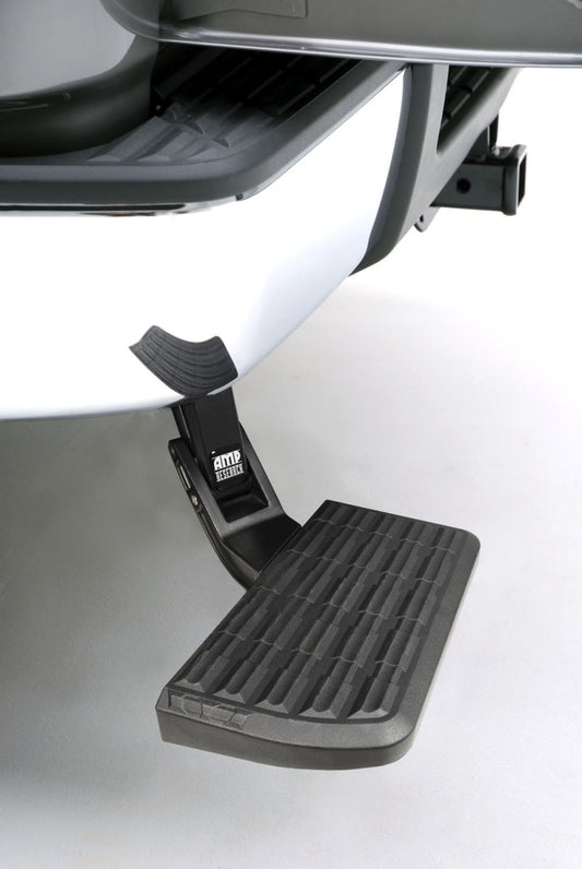 A close-up of a black AMP Research BedStep, designed for the 2007-2013 Chevrolet Silverado 1500, is attached to a vehicle. The step has a textured, non-slip surface and is shown in the lowered position, ready for efficient cargo loading.