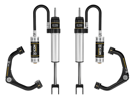 Product Name: ICON 2020+ GM HD 0-2in 2.5 Series RR Shock System w/Tube UCA showcases car suspension components, including two stylish silver shocks with black and silver reservoirs, both from the renowned 2.5 Aluminum Series by ICON, alongside two sophisticated black upper control arms accented with yellow elements, beautifully highlighted against a white background.