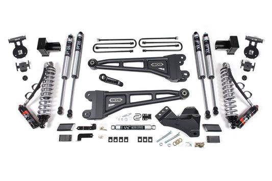 A meticulously arranged collection of BDS 4 Inch Lift Kit With Radius Arm components, intended for a Ford F250/F350 Super Duty (17-19) Diesel 4WD, featuring two black control arms, four FOX 2.5 Performance Elite coil-over shocks, two coilover springs, brackets, spacers, bolts, and other small mounting hardware displayed neatly on a white background.