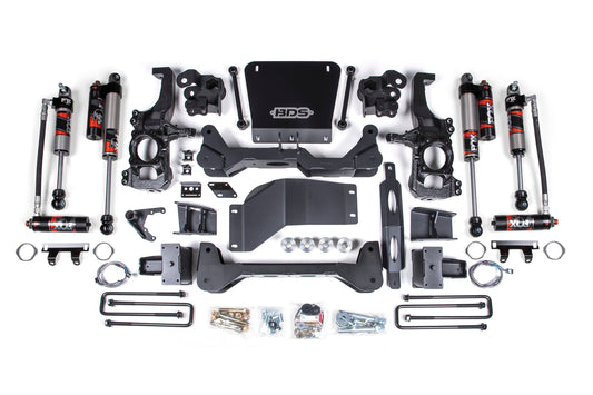 The 6.5 Inch Lift Kit | FOX Performance Elite by BDS includes various components such as shock absorbers, control arms, brackets, bolts, and other necessary hardware. The kit's parts are neatly arranged on a white background with a central plate featuring the "BDS" logo. This product is ideal for installing your 2020-2024 Chevy Silverado or GMC Sierra 2500HD/3500HD (20-24) 4WD lift kit.