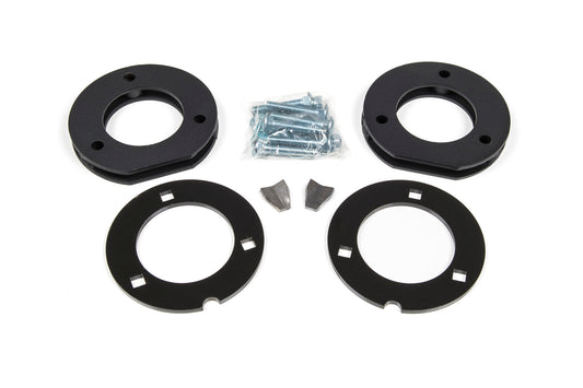 Image displaying the 2 Inch Leveling Kit for Chevy/GMC 1500 Truck/SUV (07-13) by BDS. The kit includes two circular black metal plates with central holes, three sets of bolts and screws, and two small metallic wedge-shaped pieces, all neatly arranged against a white background.