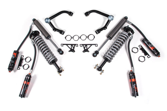 A 2 Inch Lift Kit by BDS for a Chevy Silverado or GMC Sierra 1500 (07-18) 4WD is laid out on a white background. The kit includes two FOX 2.5 coil-over shocks, shock absorbers, upper control arms, mounting brackets, and several ring clamps. All parts are arranged symmetrically.