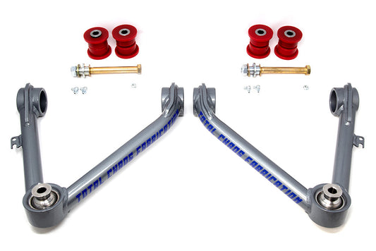 Symmetrically positioned, two identical gray metal control arms feature blue "TOTAL CHAOS" text. They are ideal for lift kits and include red bushings, gold bolts, and small hardware on a white background. Product: 07-18 Tahoe/Yukon Upper Control Arms by TOTAL CHAOS.