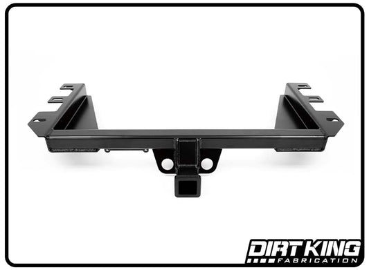 A black, heavy-duty steel trailer hitch receiver for a 99-18 GM 1500 Plate Bumper against a white background, featuring a logo reading "DIRT KING" in the bottom right corner. The hitch showcases a square receiver in the center and multiple mounting points on each side, specifically designed to enhance ground clearance for your vehicle.