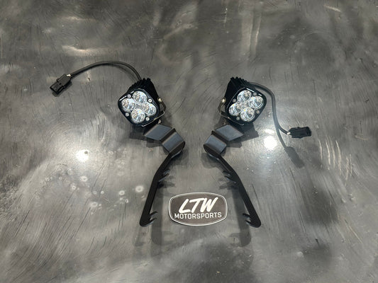 The LTW Motorsports 19-25 Chevy Silverado 1500 A Pillar Light Bracket Kit includes two Baja Designs lights with three bulbs each, neatly connected cables, and the "LTW Motorsports" logo beneath them, perfect for your Chevy Silverado.
